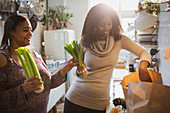 Mother and daughter unloading groceries in kitchen