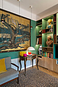 Large artwork and bookshelf with busts in lounge with green walls