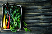 Colourful chard and spinach in a wooden crate