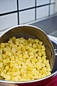 Draining washed, diced potatoes