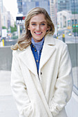 A young blonde woman wearing a white coat