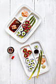 Bentobox Sushi platters with green asparagus and soy sauce