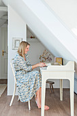 Blonde woman sitting at the desk under the umbrella