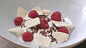 Joghurt mit Baiser, Himbeeren und Schokoraspel zubereiten