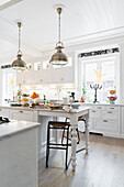 Island counter in festively decorated, white kitchen