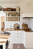 White fitted kitchen over corner with wooden worktop