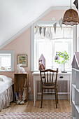 Girls' room with a pink wall in country style in the attic