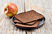 Three slices of pumpernickel bread and an apple