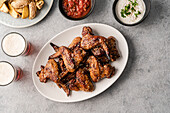 Teriyaki chicken wings with dips, potato wedges and beer