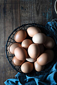 Eggs in a wire basket on a wooden background