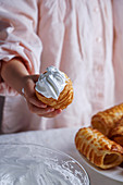 Little girl hand holding sweet pastry with cream