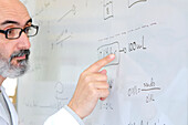 Teacher explaining chemistry on a whiteboard