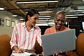 Happy businesswoman working at laptop in office