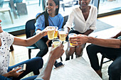Business people toasting beer glasses in office