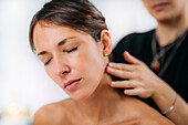 Ayurveda practitioner massaging neck with ethereal oil