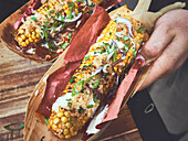 Grilled corn on the cob with sour cream and spices