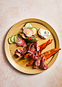 Steak strips with sweet potatoes and cucumber and radish salad