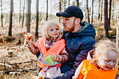 Father and daughters having picnic in forest