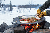 Preparing food over campfire