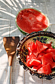Halved watermelon and melon pieces in aceramic bowl