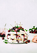 Layered meringue pavlova with cherries and cream