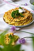 Zucchini waffles topped with sour cream and parsley