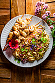 chicken skewers with noodles and cashews