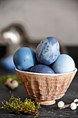 Easter eggs colored with red cabbage and blueberries in a bowl