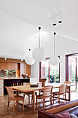 Dining area with sphere pendant lights in a bright, open living room