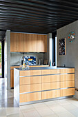 Kleine Küche mit hellen Holzfronten in offenem Wohnraum