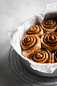 Cinnamon buns in a round pan with parchment paper.