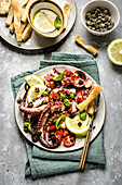 Hot octopus salad with cherry tomatoes and lemon