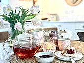 Frühstückstisch mit Teekanne und Tulpen