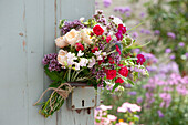 Sommerstrauß aus Rosen, Oregano, Geißraute, Vexiernelke, Staudenwicke, Kugeldistel und Gierschblüte an Türe