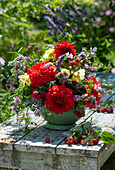 Summer arrangement in a kitchen colander: dahlias, hollyhocks, oregano, Anise hyssop, crownvetch, raspberries and bellflowers