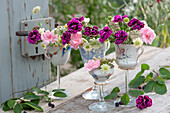 Unusual decoration idea with carnations, Knautia, and Queen Anne's Lace in cups on glass base, branch of Shadbush