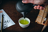 Japanischen grünen Tee in Teeschale einschenken