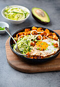 A breakfast bowl with zoodles, sweet potatoes and fried egg