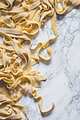Fresh uncooked pasta on a marble surface