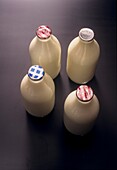 Four pint glass bottles of milk of different types