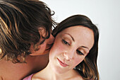 Man kissing woman on cheek