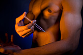 Young man injecting anabolic steroids