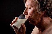 Elderly man drinking a glass of milk
