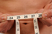 Young man checks his waistline