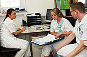 Doctors and nurses discussing patient records