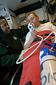 Paramedic monitors a patient