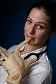 Nurse removing latex glove with her mouth
