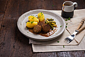 Vegan falafel with potatoes, yellow and green beans and sauce