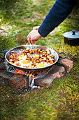 Cooking halloumi hash on camp fire