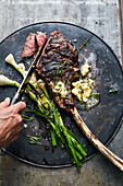 Grilled tomahawk steak with spring onions and chilli herb butter